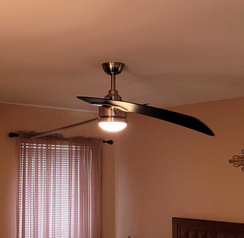 Ceiling fan installation with modern design and integrated light fixture in a residential setting, showcasing indoor comfort solutions by Nalset Electrical Services.