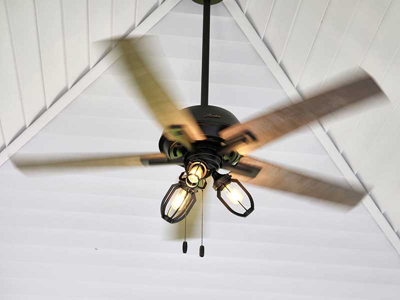 Ceiling fan installation with wooden blades and decorative light fixtures, showcasing residential electrical work by Nalset Electrical Services.