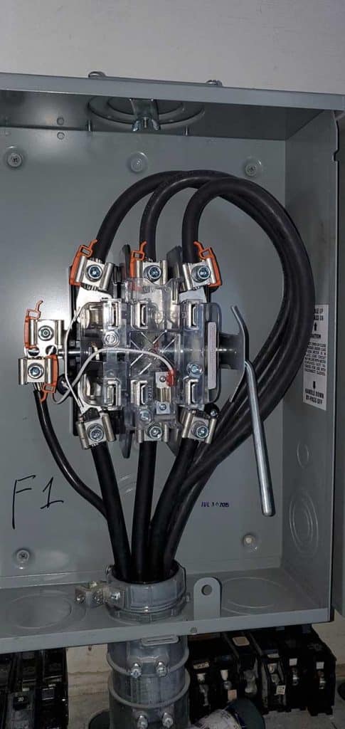 Disconnect box installation with electrical connections and cables, showcasing the internal components and wiring setup for residential electrical services.