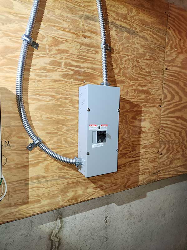 Disconnect box installation on wooden wall, featuring electrical conduit and circuit breaker, showcasing Nalset Electrical Services' expertise in residential electrical upgrades.