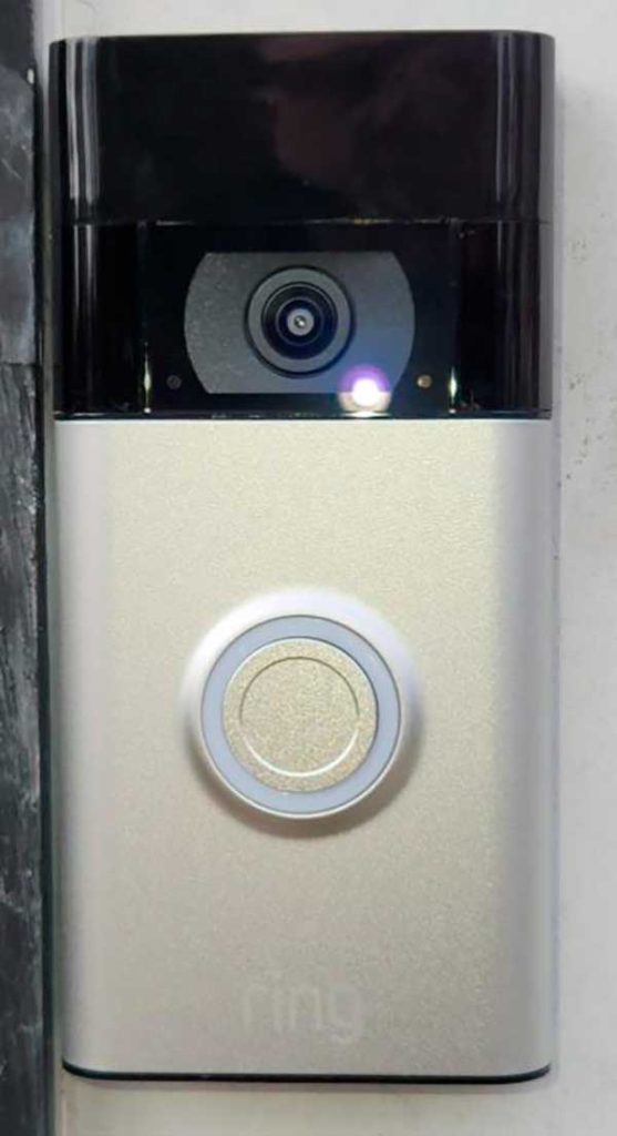 Doorbell camera installation featuring a Ring device mounted on a wall, showcasing its camera and button for residential security enhancements.