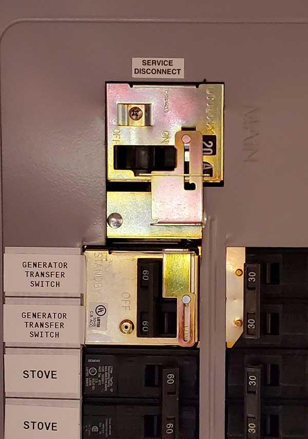 Service disconnect and generator transfer switch on an electrical panel, showcasing residential electrical installation by Nalset Electrical Services.