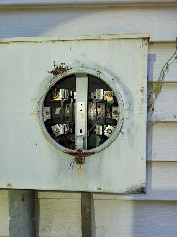 Electrical meter base with visible wiring and corrosion, highlighting unsafe electrical conditions relevant to Nalset Electrical Services' focus on electrical safety and emergency repairs.