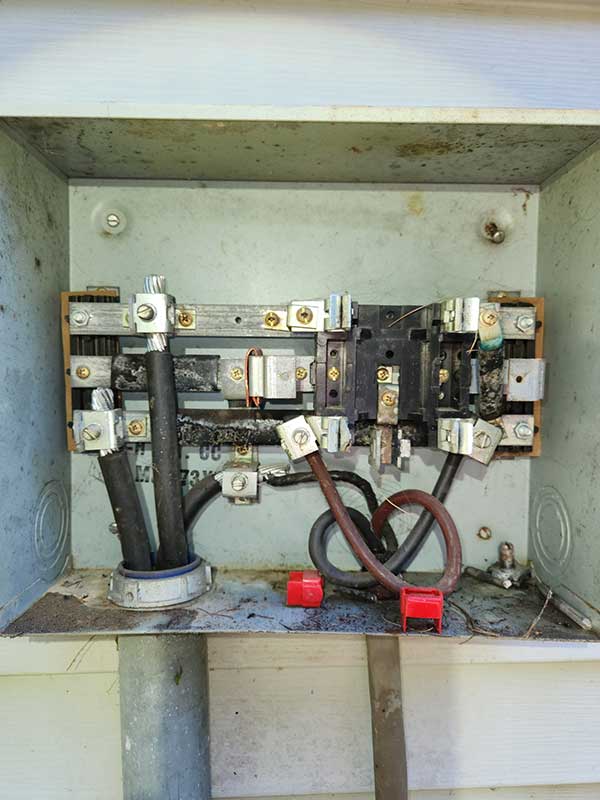 Electrical meter base installation with visible wiring, connectors, and safety features, highlighting electrical safety and readiness for emergency repairs.