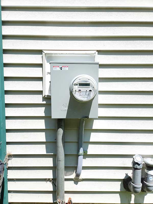Meter base installation on exterior wall with electrical meter and conduit, showcasing residential electrical service upgrades by Nalset Electrical Services.
