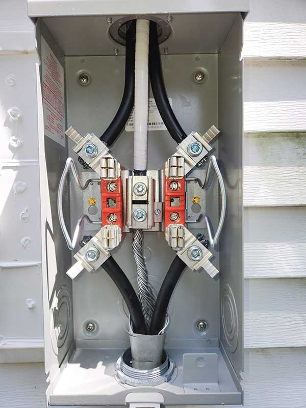 Meter base installation featuring electrical connections and wires, showcasing the interior of a residential electrical meter box.