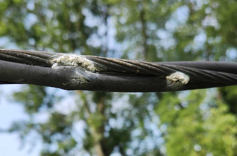 Damaged electrical cable showing exposed wires, highlighting unsafe electrical conditions relevant to emergency repairs and electrical safety inspections.